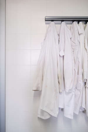 Dirty lab coats hanging in a laboratory. Research concept.の写真素材