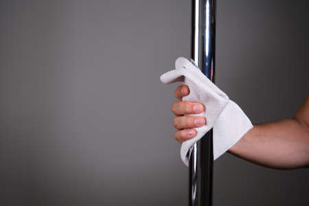 Hand cleaning a metallic pole with a cloth. Cleaning concept.の写真素材