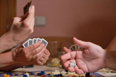 Unrecognizable family hands playing board games. Having fun at home concept.の写真素材