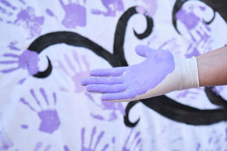 A hand painted purple participating in the International Day for the Elimination of Violence against Women participatory mural. 25 november.の写真素材