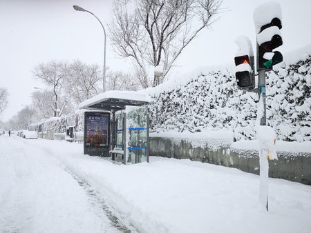 Madrid, Spain. January 09, 2021: Snowstorm, blizzard on streets, bus stops covered. Snowing in winter.のeditorial素材