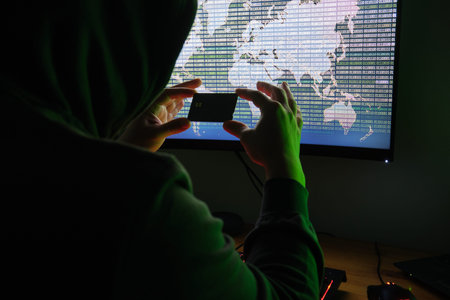 Hacker holding a credit card front of a computer for organizing massive data breach attack around...