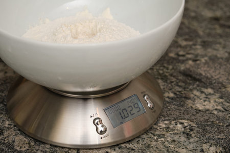 Weighing flour for baking on a digital scale. Preparing bread at home.の写真素材
