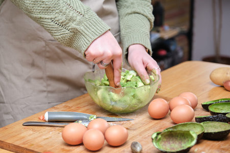 Unrecognizable woman smashing avocados. Cooking mediterranean and healthy food.の写真素材