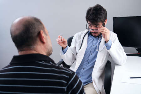 Young doctor health care professional prescribing medicine to a senior man patient. Medicament prescription.の写真素材