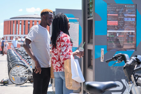 Madrid, Spain. May 29, 2021: Young african tourists renting a bike at a bicycle rental service...
