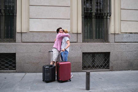 A couple of happy tourist hugging when then re-encounter after long time. Reunion of two friends.の写真素材