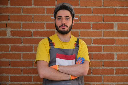 Portrait of a young caucasian construction worker arms crossed looking at camera at the construction...