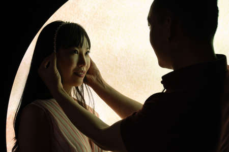 Young asian man put a crown on his girlfriend head over a moon background.の写真素材