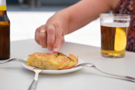 Hand taking a piece of Spanish omelette with a fork.の写真素材