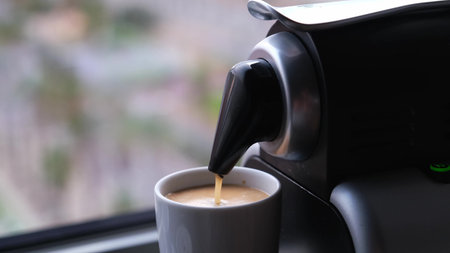 Close up of a coffee machine pouring an expresso in a cup.