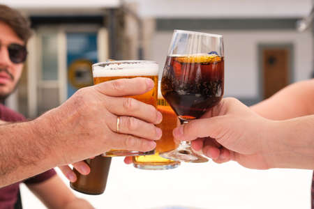 Group of people making a toast with beer and cola drink.の写真素材