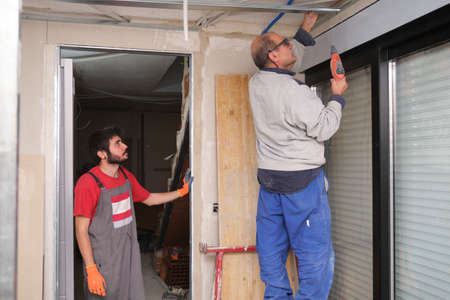 Contractor teaching how to assemble a suspended ceiling metal frame.の写真素材