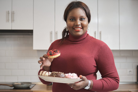 Portrait of a young cuban woman holding a plate of doughnuts and smiling.