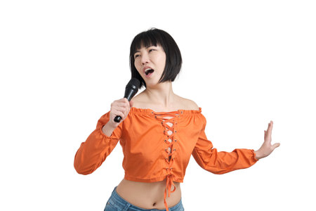 Young asian woman singing and dancing with microphone, isolated on white background.
