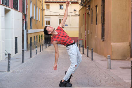 Young caucasian man with long false nails dancing at street, steps of contemporary dance.の写真素材