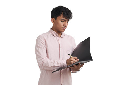 Young peruvian man writing on a folder with a pen. Isolated over white background.の写真素材