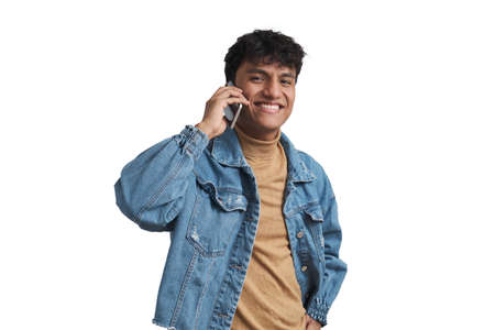 Young peruvian man smiling and speaking on the smartphone. Isolated over white background.の写真素材