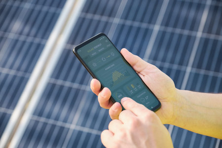 Unrecognizable person checking the solar power generation of solar panels domestic installation in a...