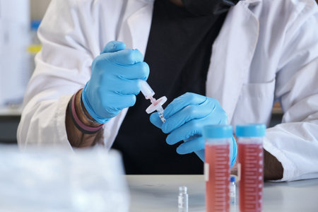 Scientist in white lab coat filter sample into HPLC vial. High performance liquid chromatography at...
