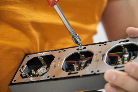 Close up of a man hands unscrew power socket with screwdriver to install it.の写真素材