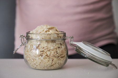 Jar full of blanched sliced almonds. Food in bulk.