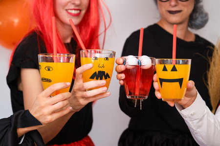 Four people doing a toast at a costume Halloween party in a house.の写真素材