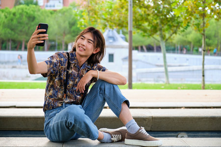 Young Asian man taking a selfie with the smartphone at street.の写真素材