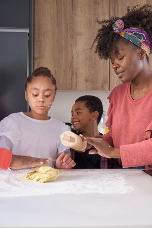 African family kneading cookie dough in the kitchen. Horizontal extended family.