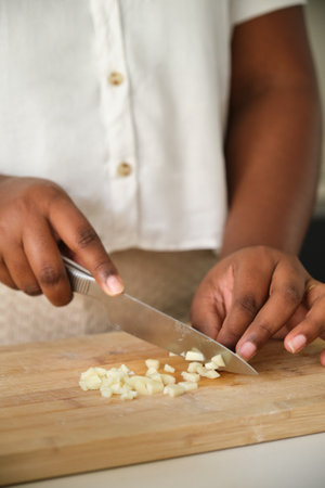 Close up of cuban woman hands cutting a raw garlic using a knife.の写真素材