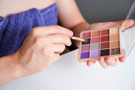 Male hands choosing the right color of eyeshadow from a case.の写真素材