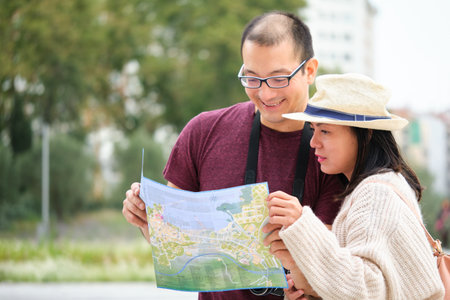 Multiracial couple of tourists consulting a city map. Sightseeing in Madrid, Spain.の写真素材
