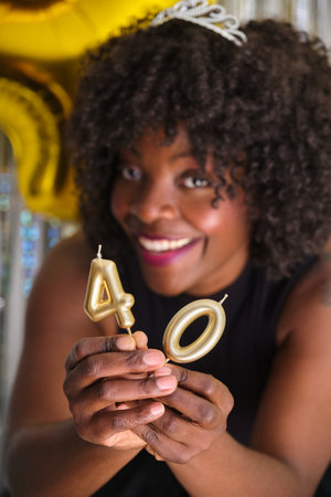 African woman smiling in her 40 birthday party with 40 birthday golden candles.の写真素材