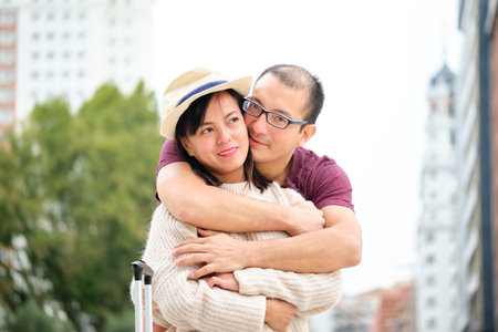Multiracial couple of tourists smiling, hugging and looking at camera. Sightseeing in Madrid, Spain.の写真素材
