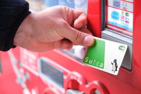 Kyoto, Japan. April 18, 2023: Close up of a hand paying with suica card to get a drink in a japanese vending machine, jidouhanbaiki.のeditorial素材