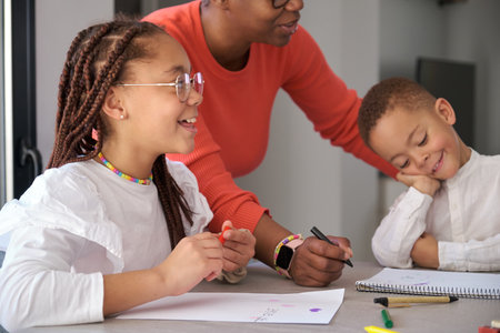 African mother painting with their children during the freetime. Horizontal extended family.