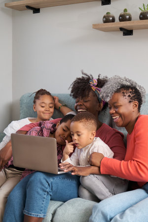 Happy african horizontal extended family having a good time in front of the laptop at home.