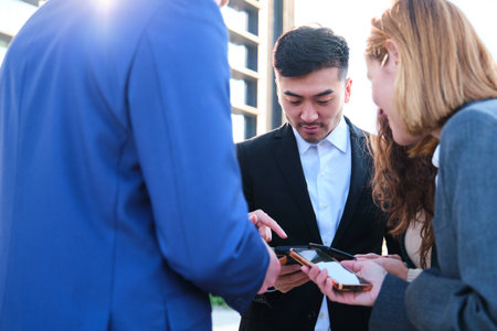 Group of Multiethnic businesspeople using their smartphones during their break at street.の写真素材