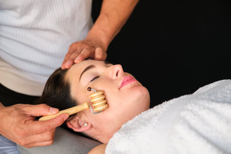 Woman getting face maderotherapy in a beauty salon. Professional skin care treatment.の写真素材