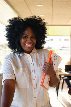 Portrait of smiling Black business woman looking at camera at a coworking. Business people.の写真素材