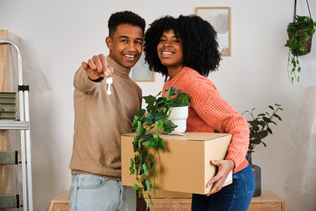 Portrait of happy young black moving in a new home. New residence relocation.の写真素材
