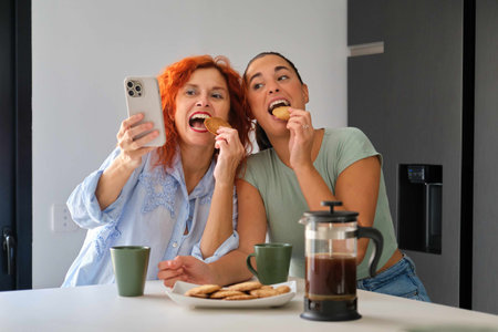 Mother and daughter taking a selfie while having breakfast. Family time.の写真素材