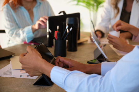 Multiethnic group of unrecognizable business people hands working at a coworking room.の写真素材