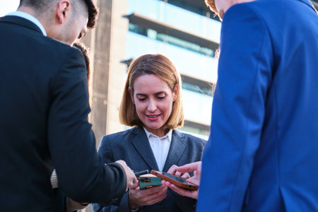 Group of busy international businesspeople using their smartphones at street.の写真素材