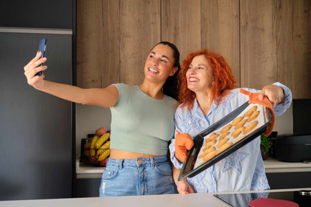 Mother and daughter taking a selfie with fresh-baked homemade butter cookies. Family time.