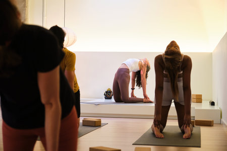 A group of people are practicing ustrasana or camel yoga pose in a room. Yoga class.の写真素材