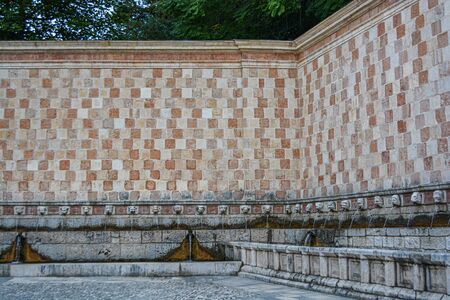 Fountain of the 99 Spouts (Fontana delle 99 cannelle), Historic fountain with 99 jets distribuited along three walls, L Aquila, Italyの写真素材