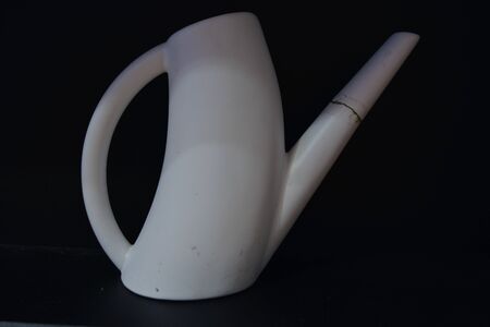 White watering can isolated on black backgroundの写真素材