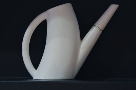 White watering can isolated on black backgroundの写真素材