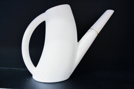 White watering can isolated on black backgroundの写真素材